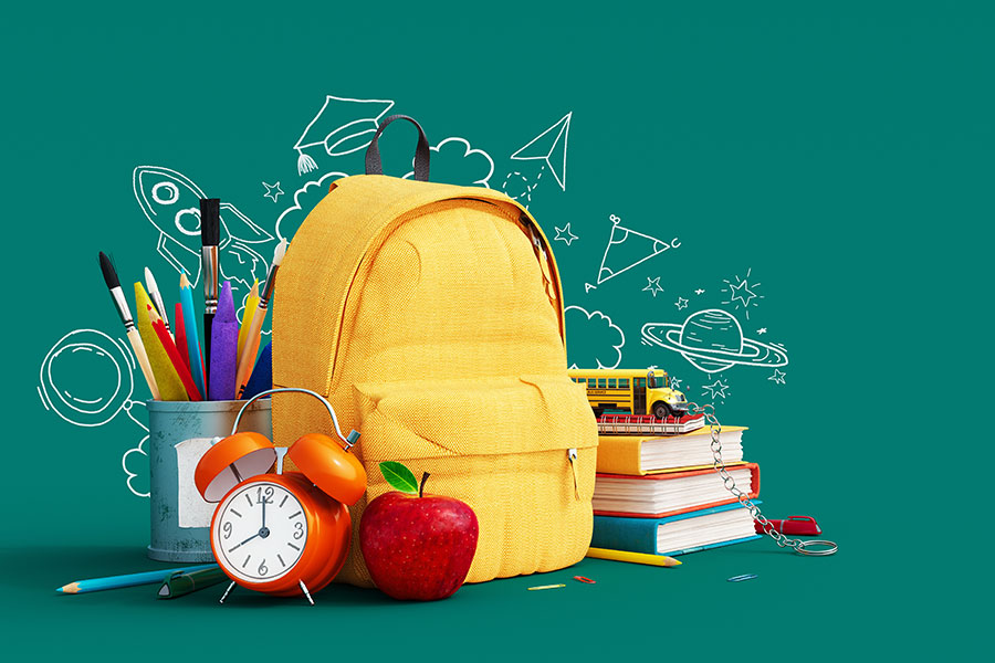 yellow backpack with school supplies surrounding it